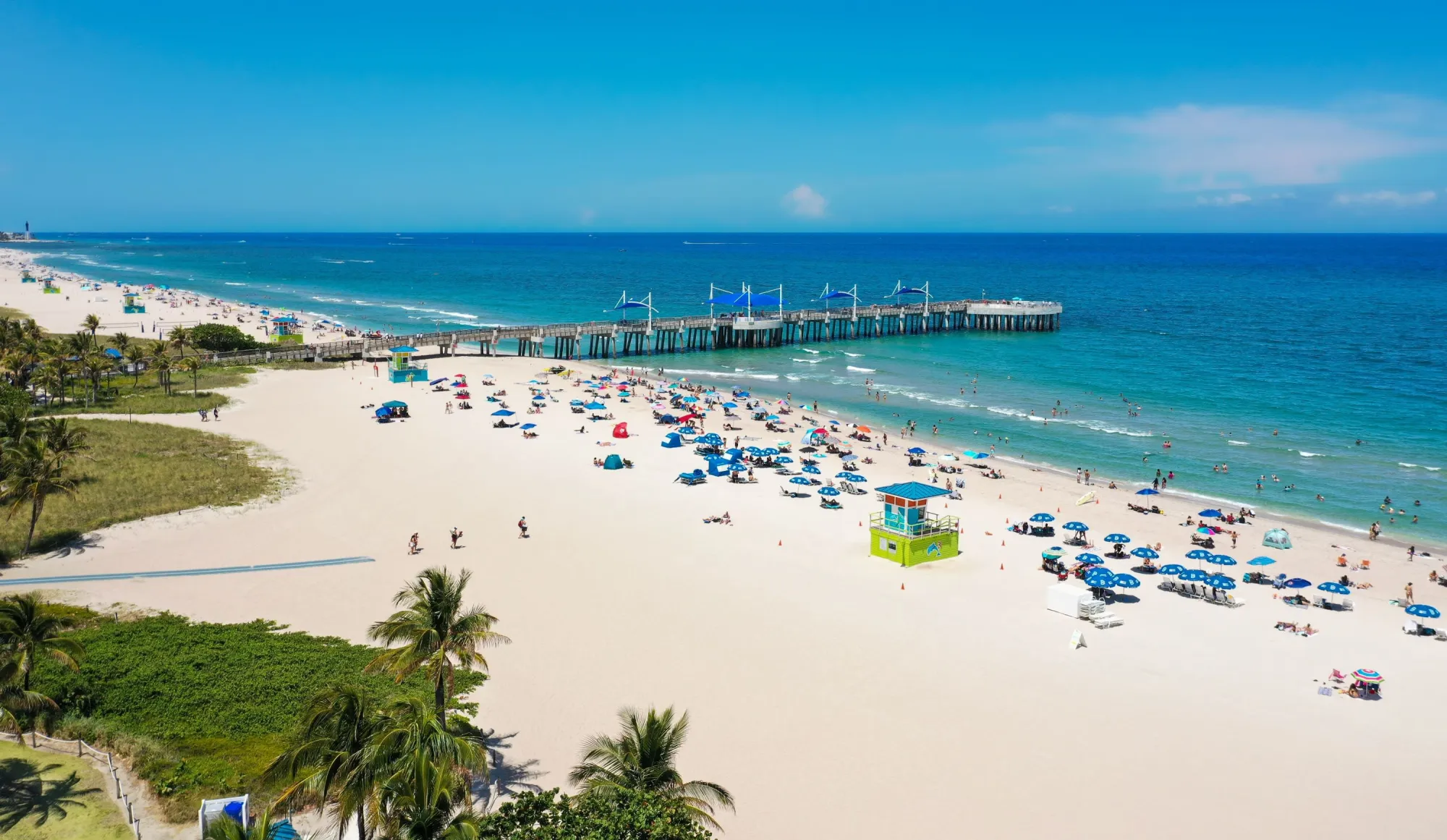 Aerial view of Pompano Beach Pier with beach umbrellas on the sand