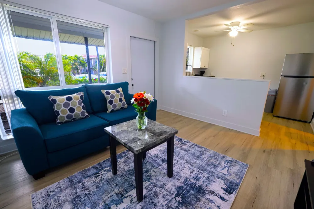 Suite living room with navy sofa and fresh flowers