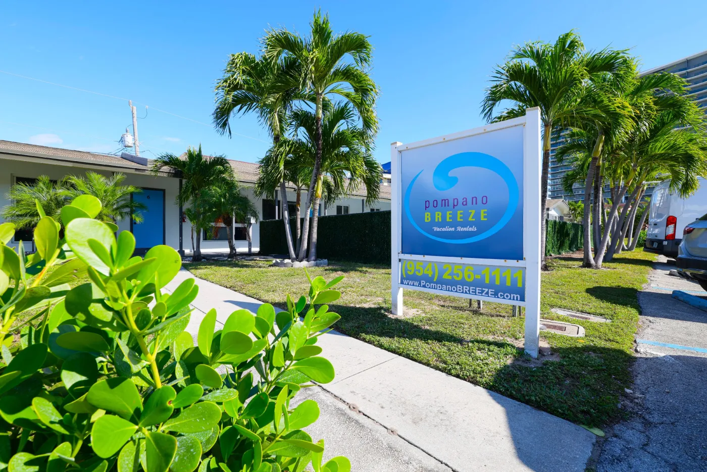Pompano Breeze roadside sign among palm trees