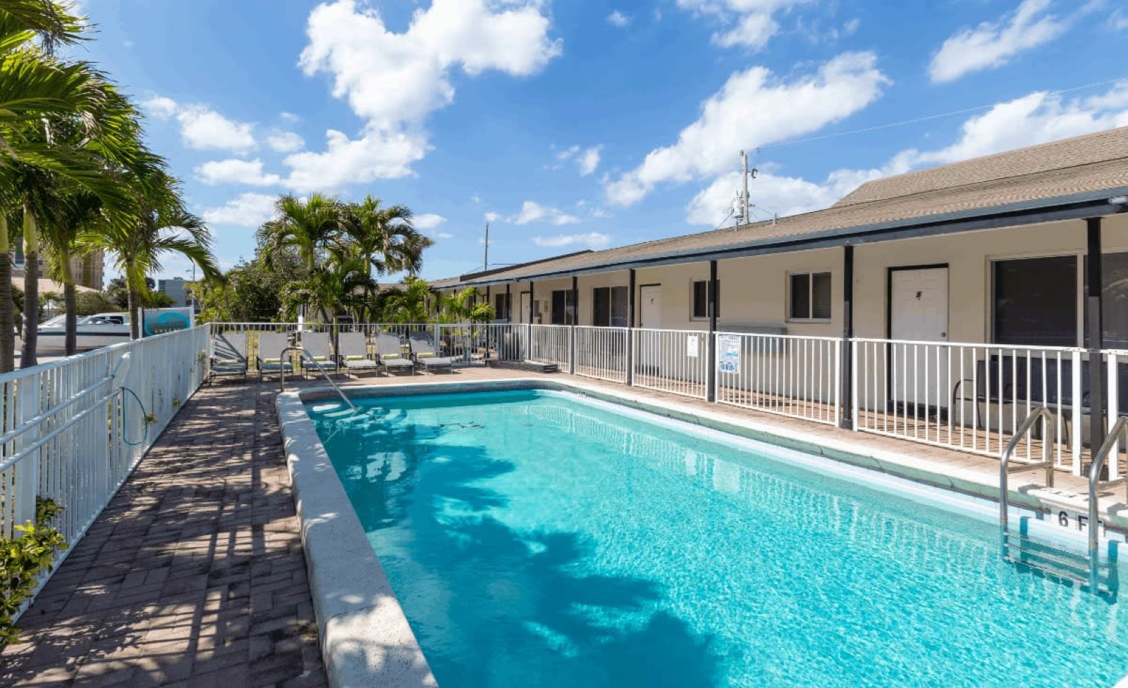 Courtyard pool framed by palm trees at Pompano Breeze