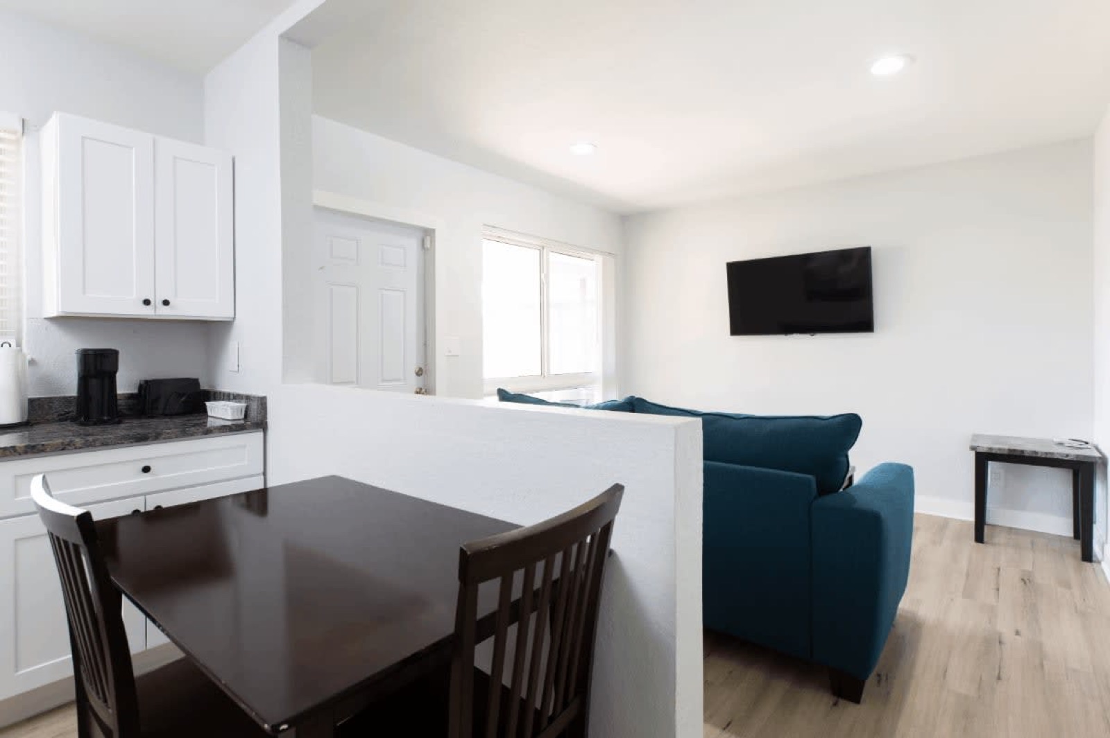 Kitchenette dining table with the living room beyond in a Pompano Breeze unit