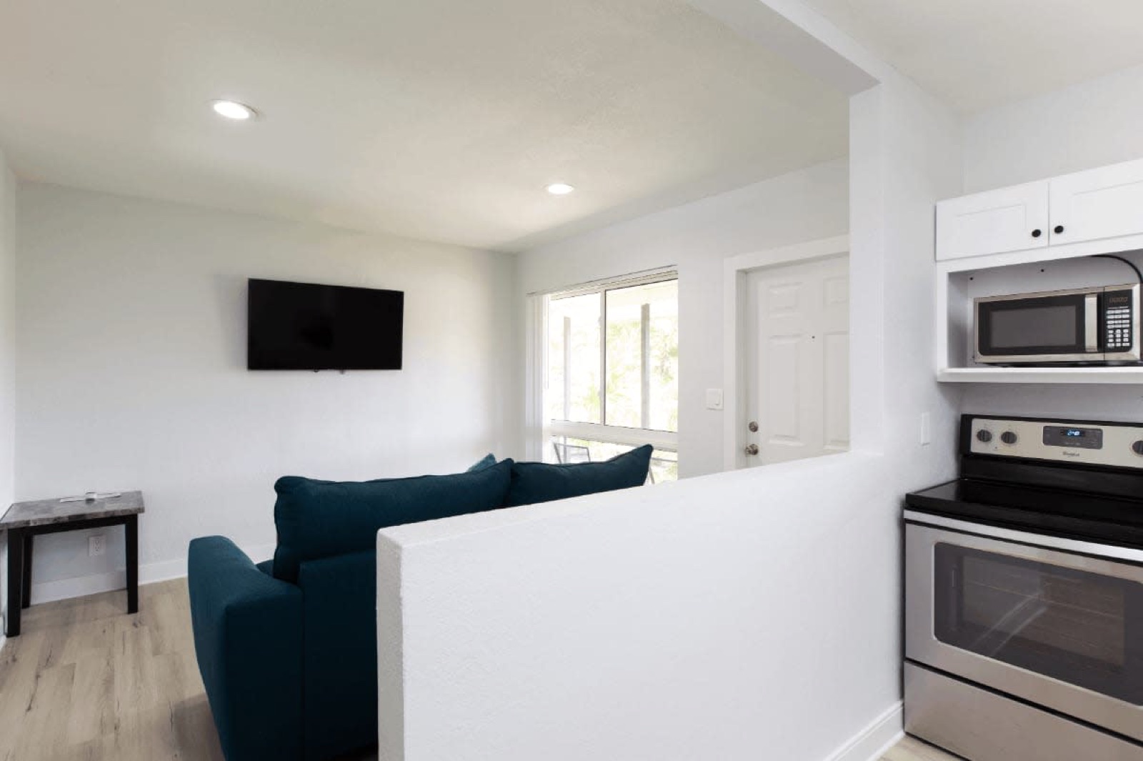 Suite living room with kitchen and stove at Pompano Breeze