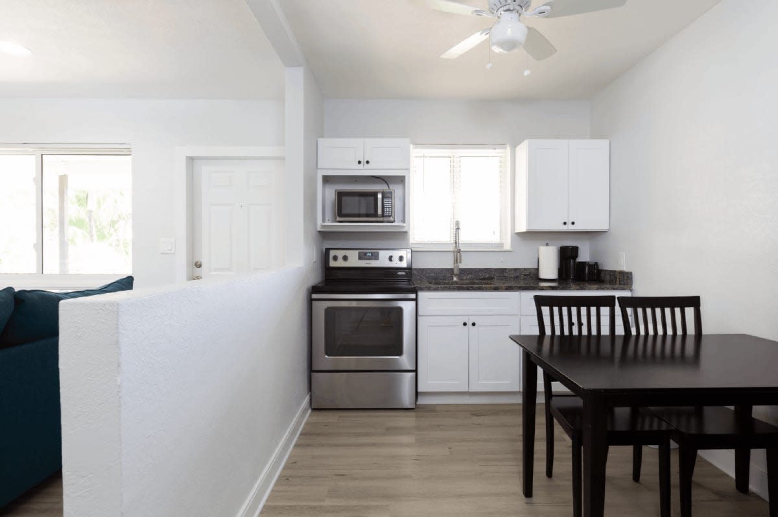 Kitchen and dining set beside living area at Pompano Breeze, Pompano Beach