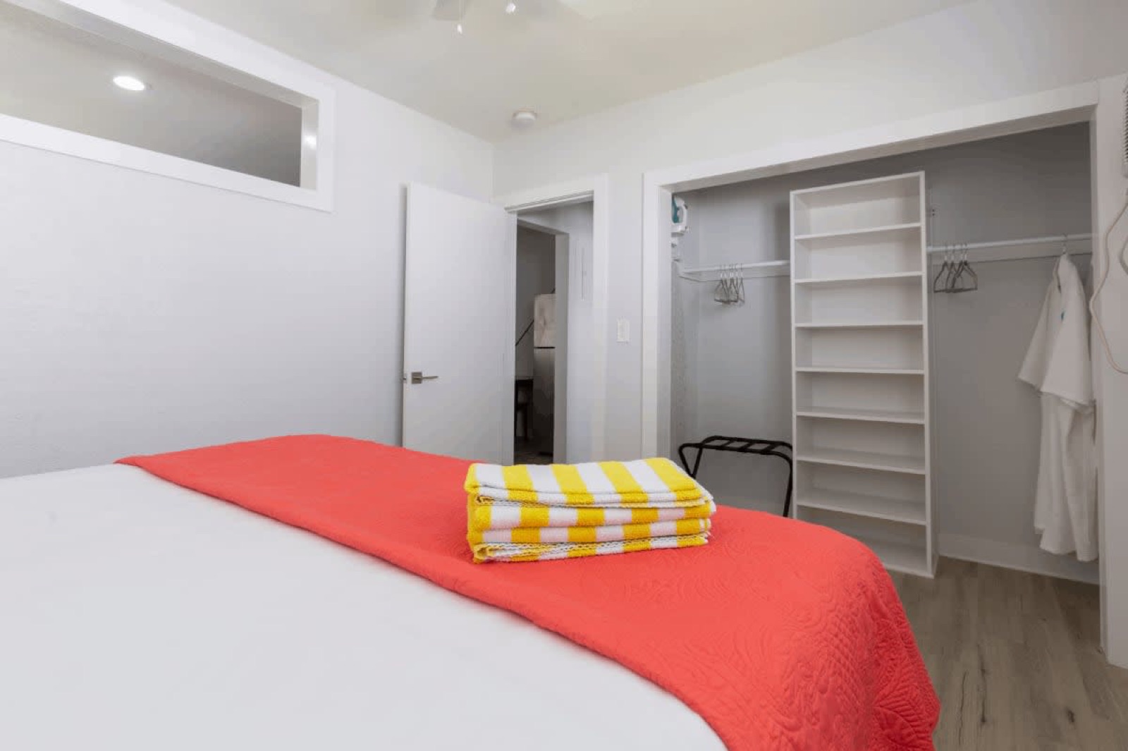 Bed with striped beach towels, open closet, Pompano Beach, FL