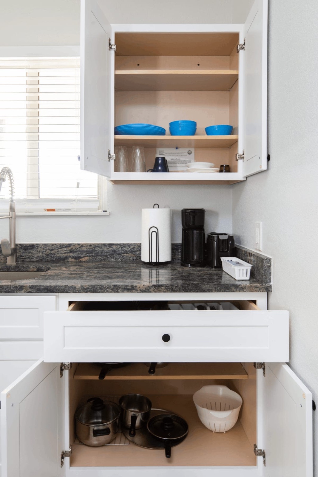 Kitchenette cabinets open showing dishes at Pompano Breeze, Pompano Beach