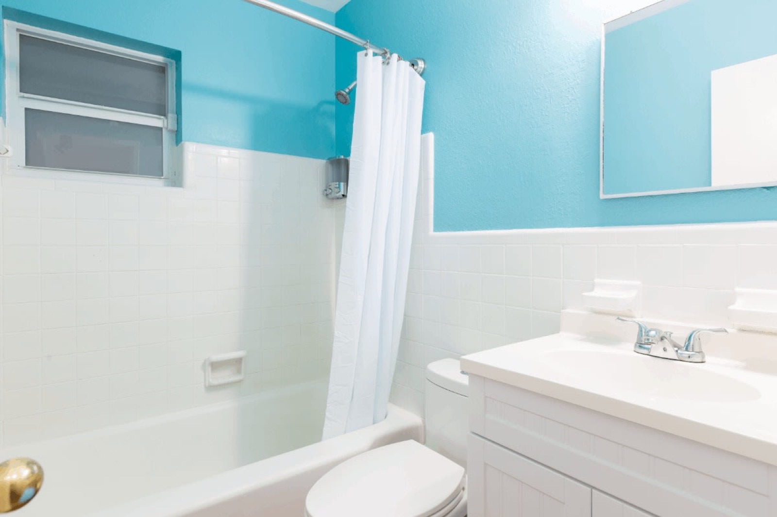 Turquoise bathroom with tub and vanity at Pompano Breeze, Pompano Beach