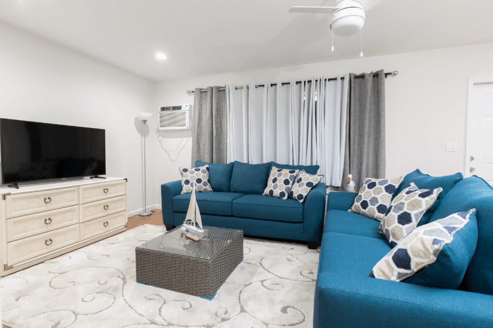 Living room with sectional sofa and TV at Pompano Breeze, Pompano Beach