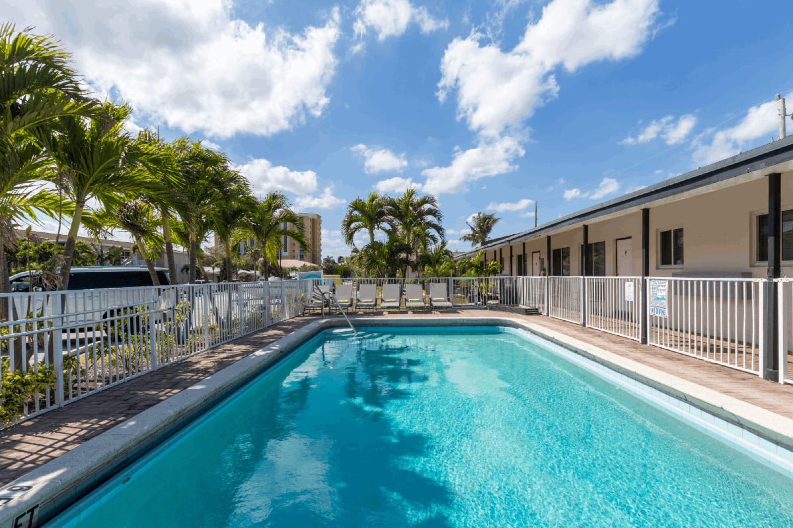 Wide view of the courtyard pool, palms and units at Pompano Breeze