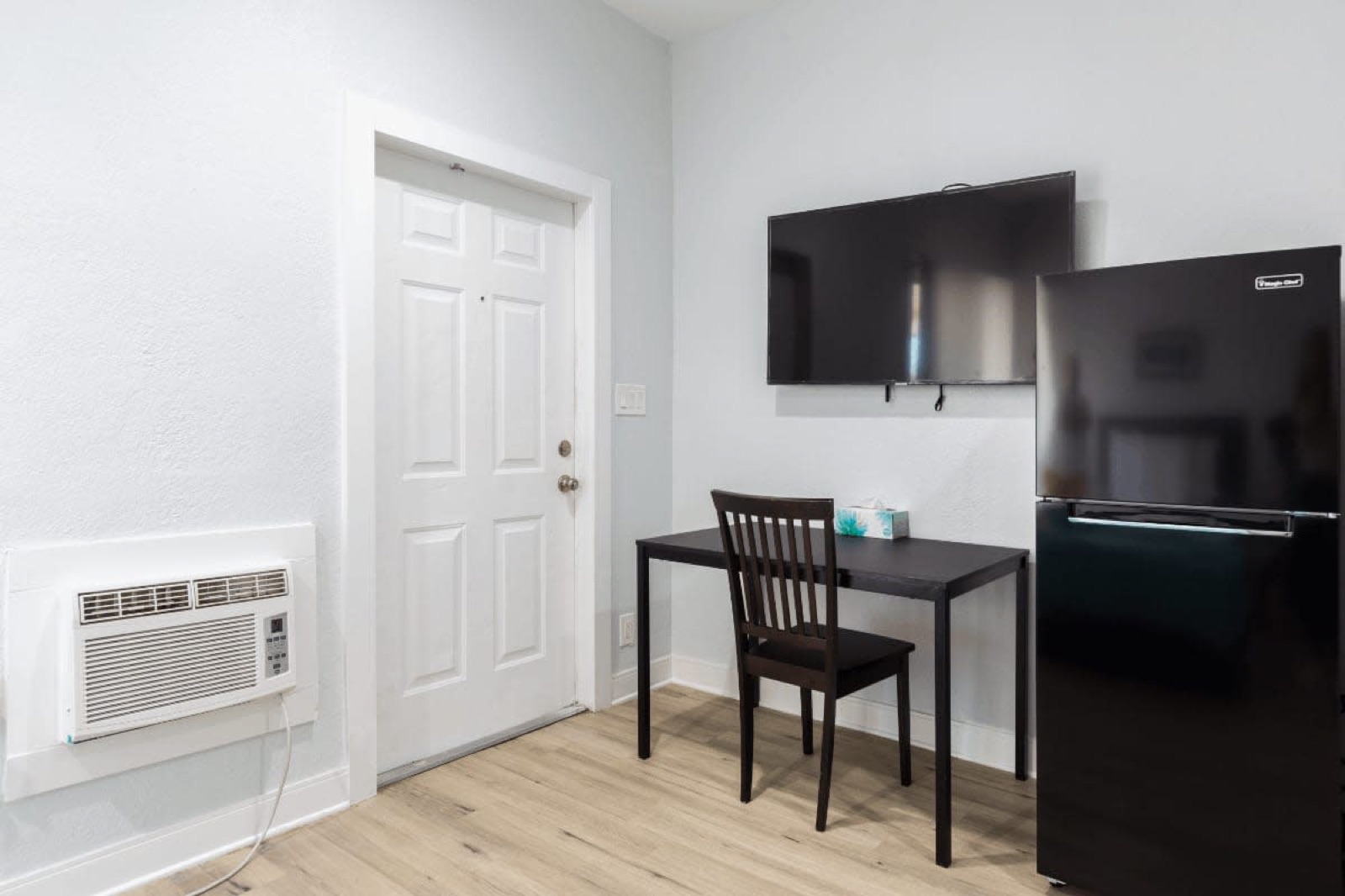 Studio with desk, TV and black fridge at Pompano Breeze, Pompano Beach