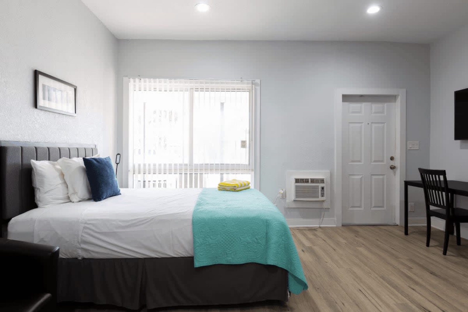 Studio bed, desk and window at Pompano Breeze, Pompano Beach