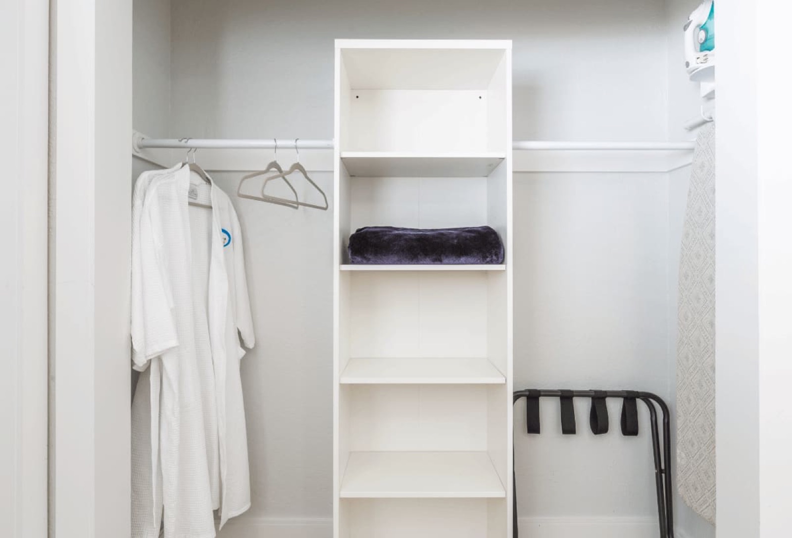Closet with bathrobe, shelves, luggage rack at Pompano Breeze, Pompano Beach