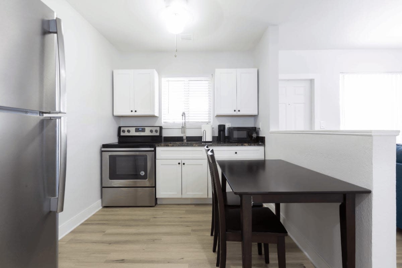 Kitchen with stainless fridge and dining set at Pompano Breeze, Pompano Beach