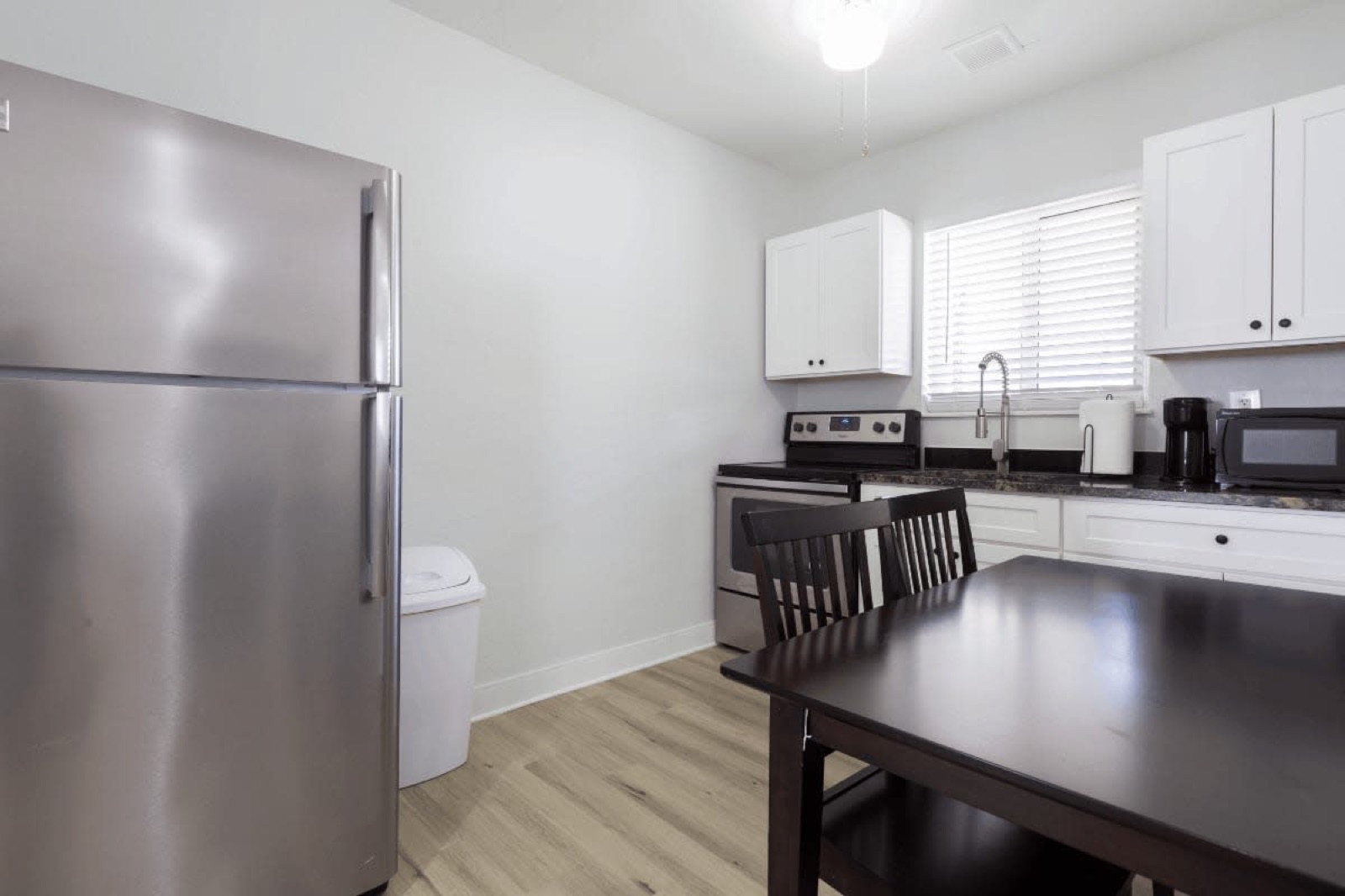 Kitchen with fridge and dining table close at Pompano Breeze, Pompano Beach