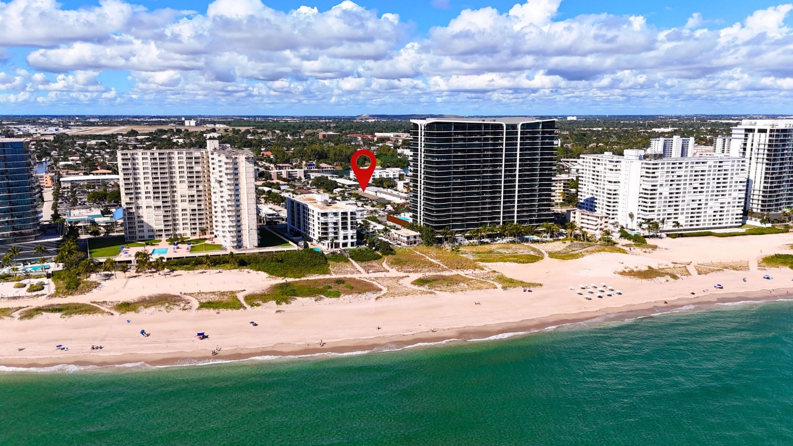 Aerial view of beachfront condos in Pompano Beach with a location pin