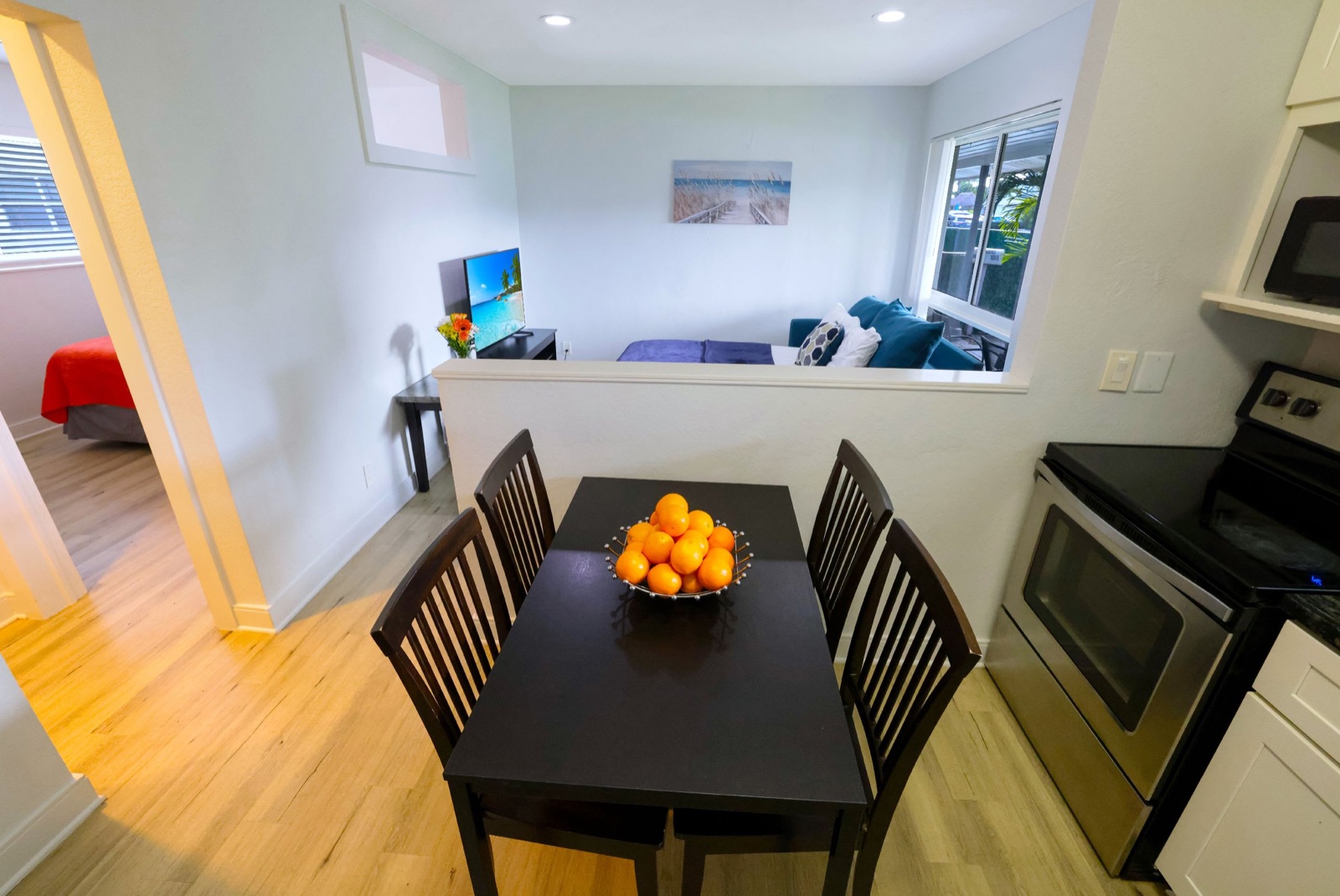 Dining table with a fruit bowl and kitchen in a Pompano Breeze suite